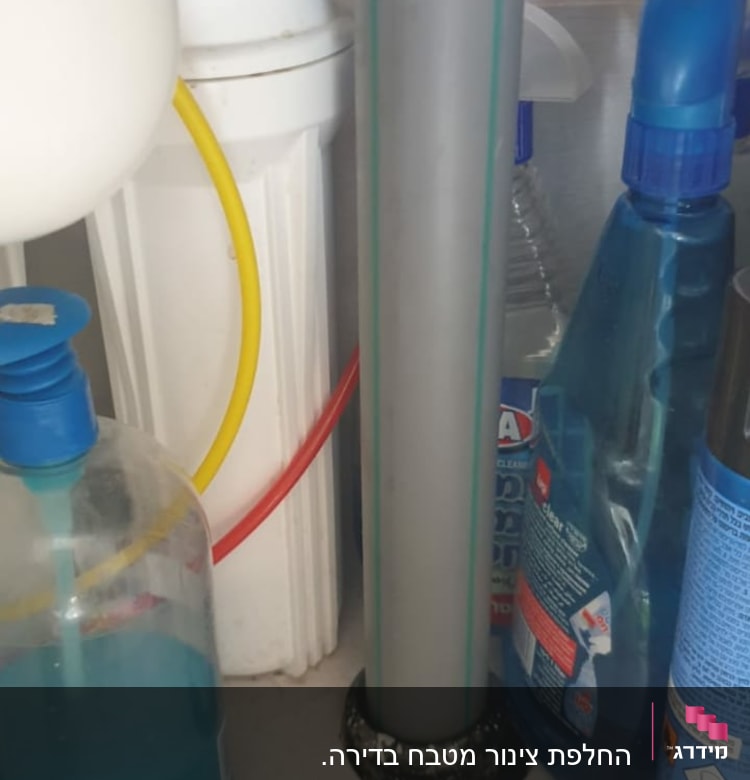 צינור אפור עם חיבורים מתחת לכיור